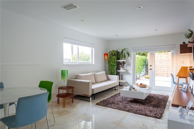 living room featuring marble finish floor, visible vents, and french doors