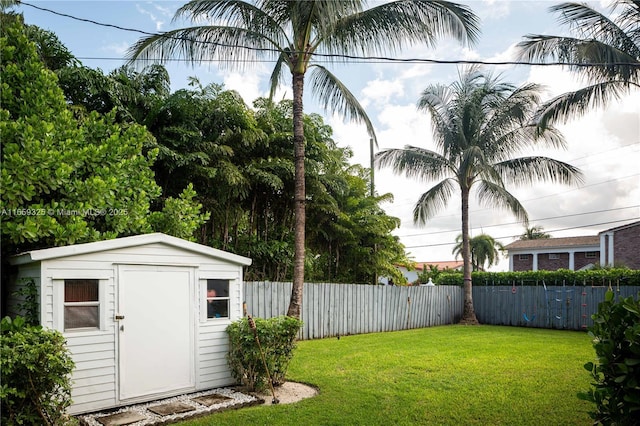 view of yard featuring a shed, an outdoor structure, and a fenced backyard