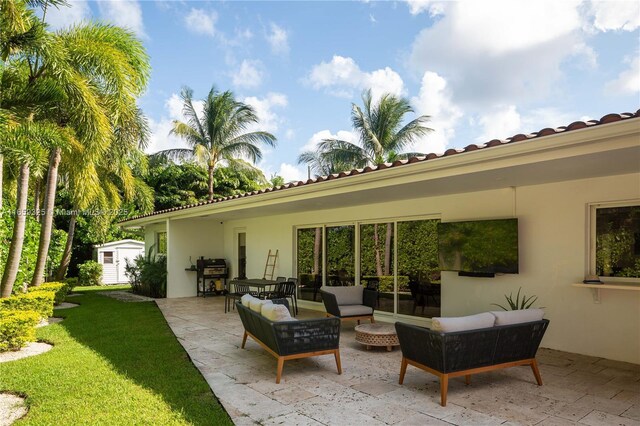 view of patio / terrace with a storage unit, outdoor lounge area, and a grill