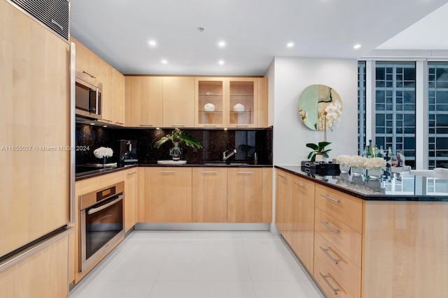 kitchen with light brown cabinets, stainless steel appliances, and kitchen peninsula