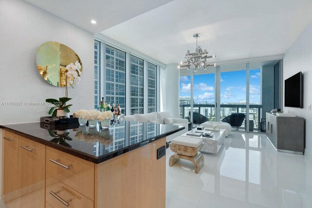 tiled living room featuring expansive windows and a chandelier