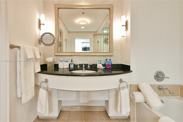 bathroom with a tub, vanity, backsplash, and tile patterned floors