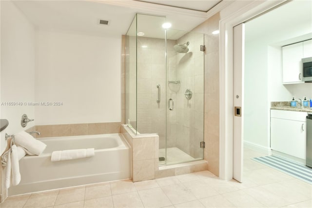 bathroom with tile patterned flooring, vanity, and plus walk in shower