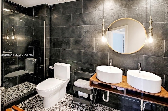 bathroom featuring toilet, tile walls, sink, and tile patterned floors