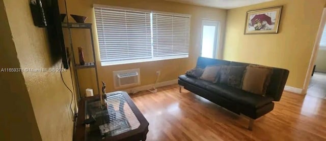 living area with hardwood / wood-style floors and a wall mounted air conditioner