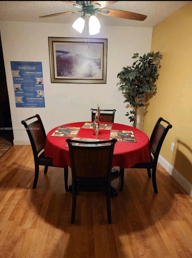 dining space with a textured ceiling, ceiling fan, and hardwood / wood-style floors