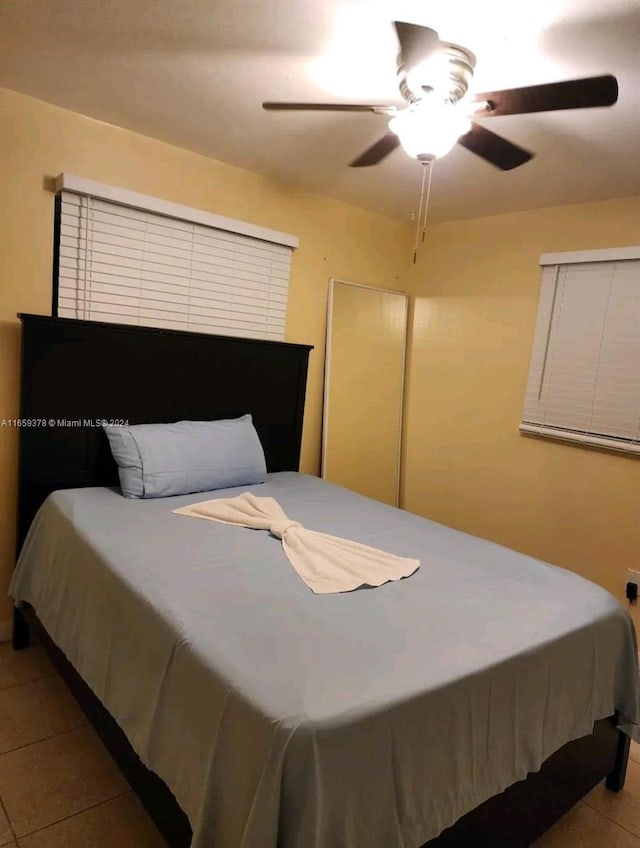 tiled bedroom featuring ceiling fan