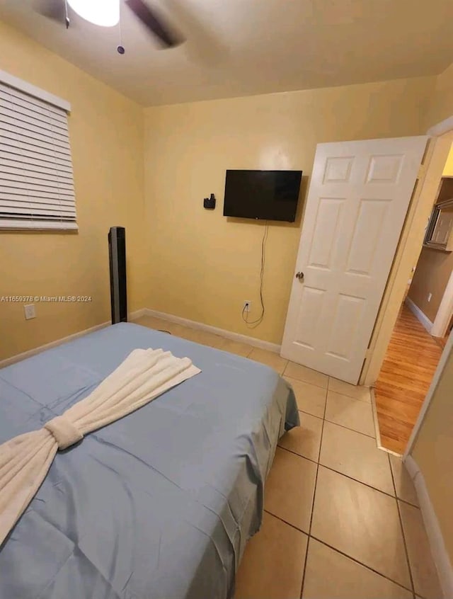 bedroom with ceiling fan and light tile patterned floors