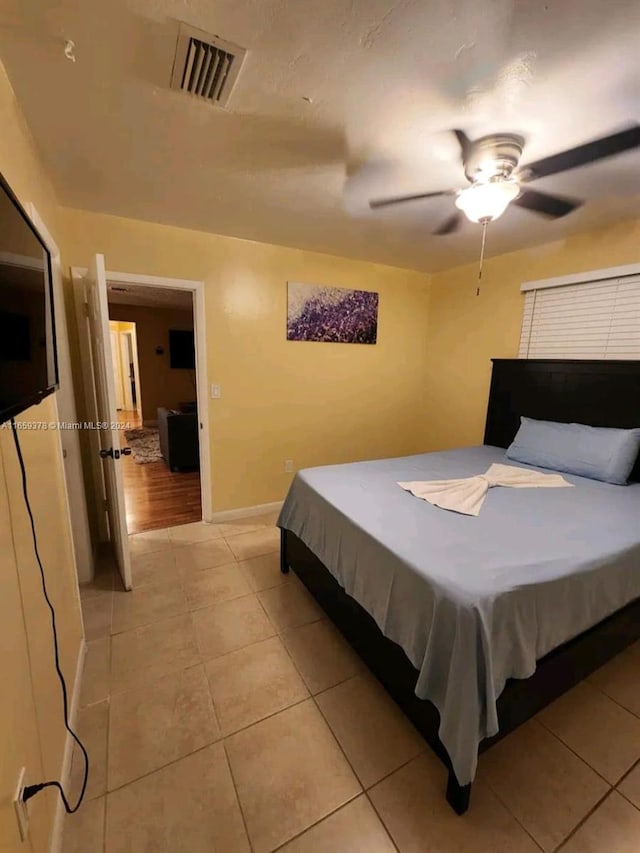 tiled bedroom with ceiling fan