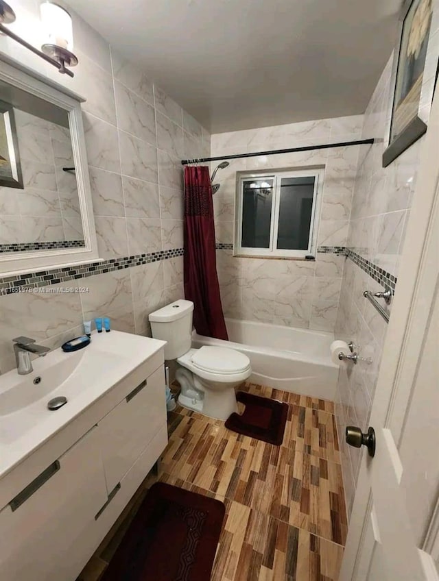 full bathroom featuring vanity, shower / bath combination with curtain, hardwood / wood-style floors, tile walls, and toilet