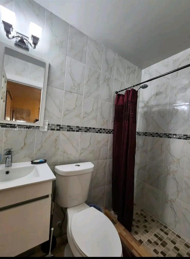 bathroom with tile walls, walk in shower, toilet, and vanity