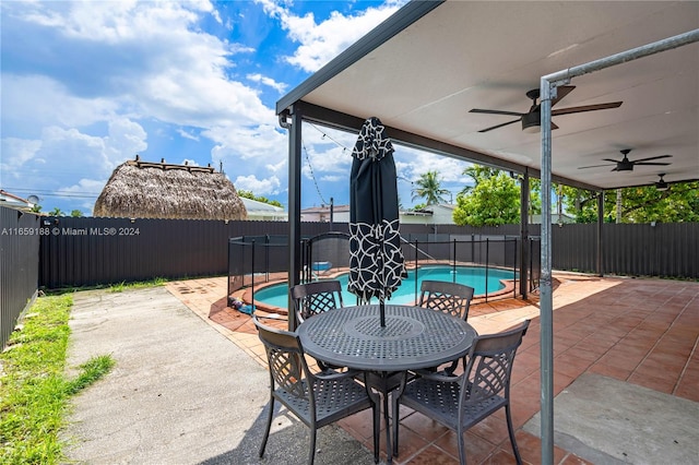 view of patio with ceiling fan and a fenced in pool