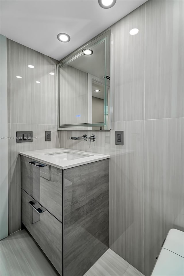 bathroom with tile walls and vanity