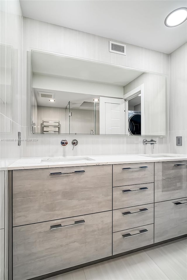 bathroom featuring washer / clothes dryer, tasteful backsplash, and vanity