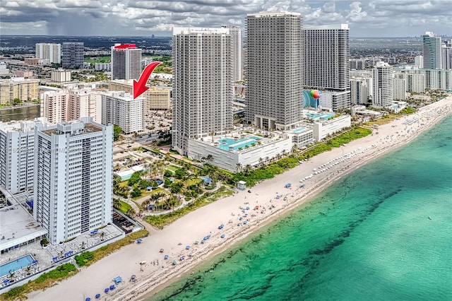 drone / aerial view featuring a beach view and a water view