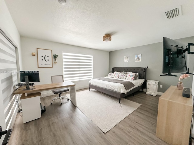 bedroom with a textured ceiling and dark wood-type flooring