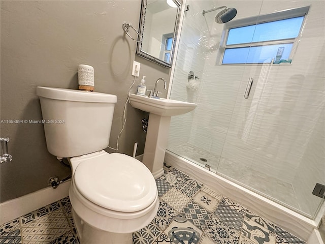 bathroom with toilet, a shower with shower door, and tile patterned flooring