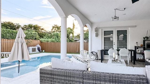 view of patio / terrace with a fenced in pool, an outdoor living space, and french doors