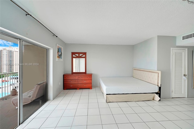 unfurnished bedroom featuring a textured ceiling, a closet, and light tile patterned floors