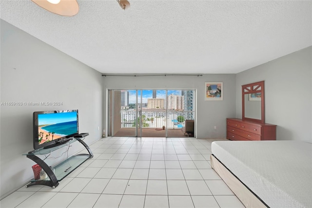 tiled bedroom featuring access to exterior and a textured ceiling