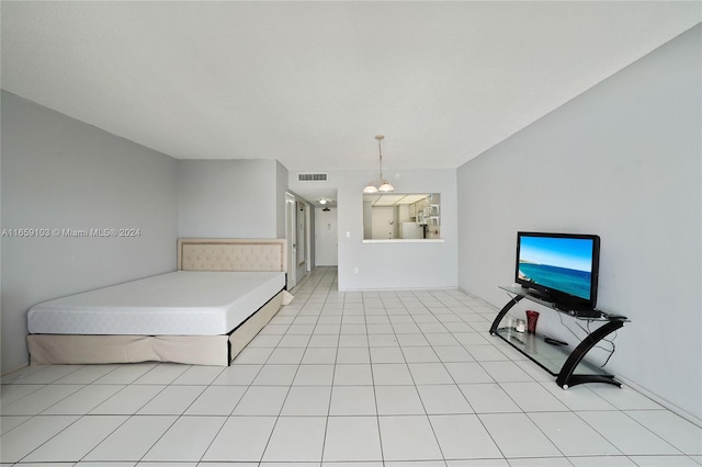 bedroom featuring light tile patterned floors and stainless steel refrigerator