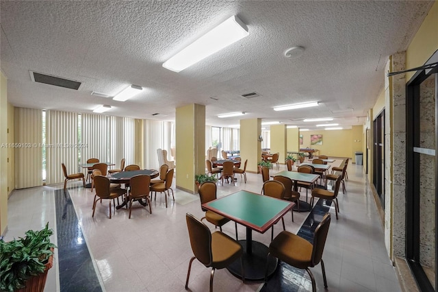 dining room with a textured ceiling and a wealth of natural light