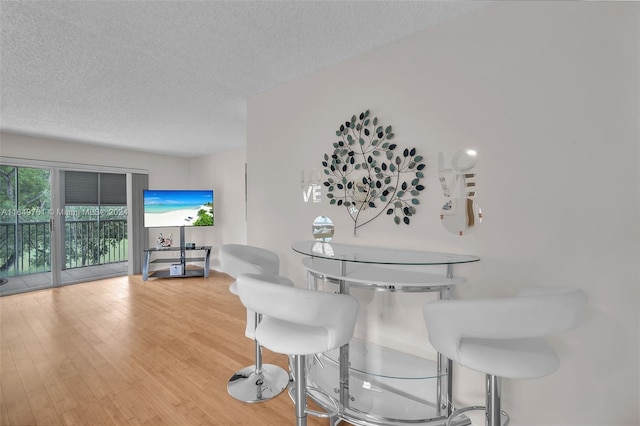 dining area featuring a textured ceiling and hardwood / wood-style flooring