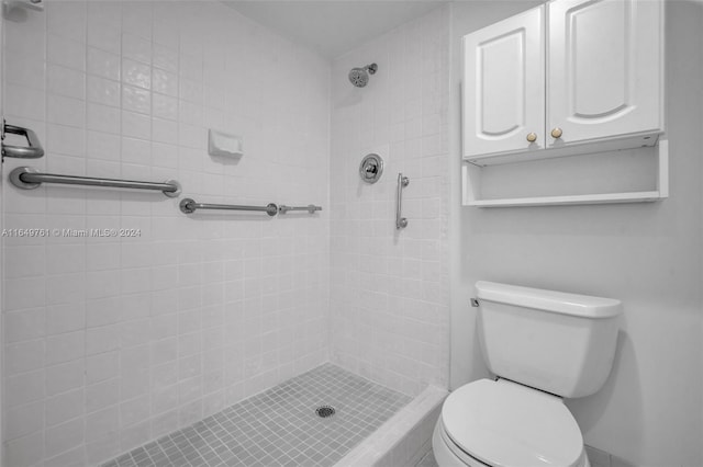 bathroom featuring toilet and a tile shower