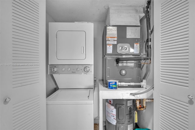 washroom with stacked washer and dryer and heating unit