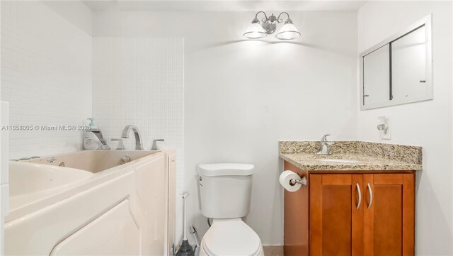 bathroom featuring a bathtub, vanity, and toilet