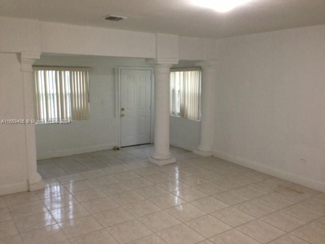 tiled empty room featuring ornate columns