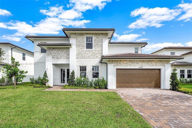 12267 SW 43rd Ct, Davie, FL 33330 - prairie-style home with an attached garage, stucco siding, a front yard, and decorative driveway