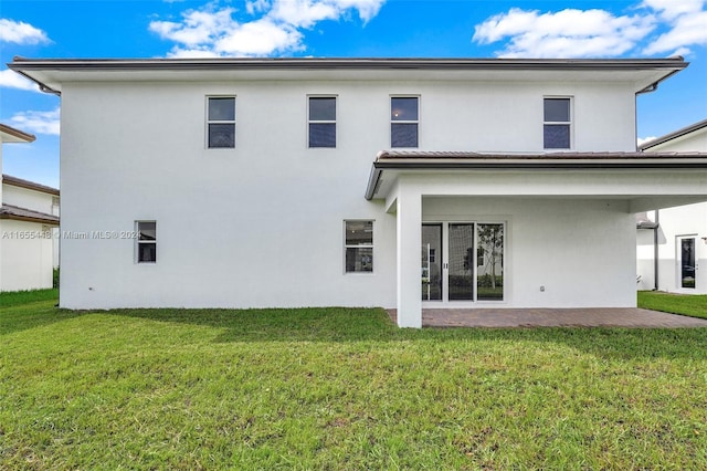 12267 SW 43rd Ct, Davie, FL 33330 - rear view of house with stucco siding, a patio area, and a lawn