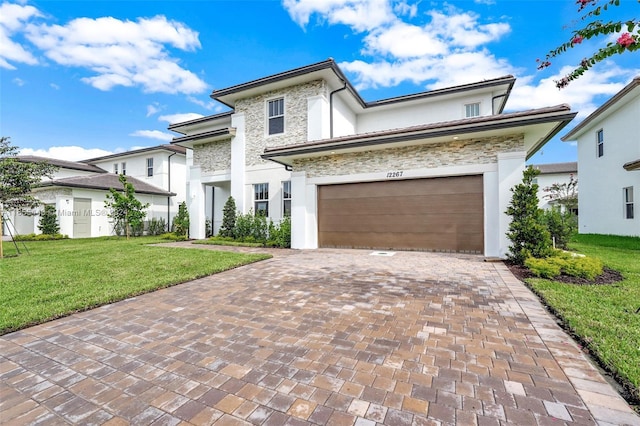 12267 SW 43rd Ct, Davie, FL 33330 - view of front of home featuring stone siding, decorative driveway, a front lawn, stucco siding, and a garage