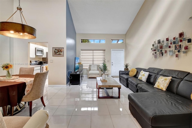 living room with high vaulted ceiling and light tile patterned floors