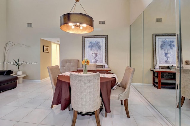 dining space featuring light tile patterned floors and a high ceiling