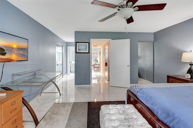 tiled bedroom featuring a textured ceiling, a closet, and ceiling fan