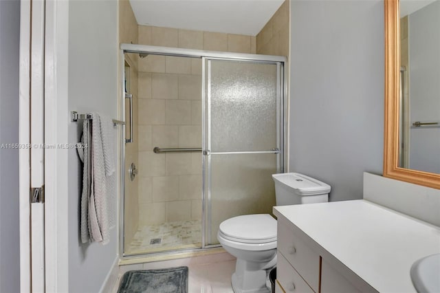 bathroom with toilet, a shower with shower door, vanity, and tile patterned flooring