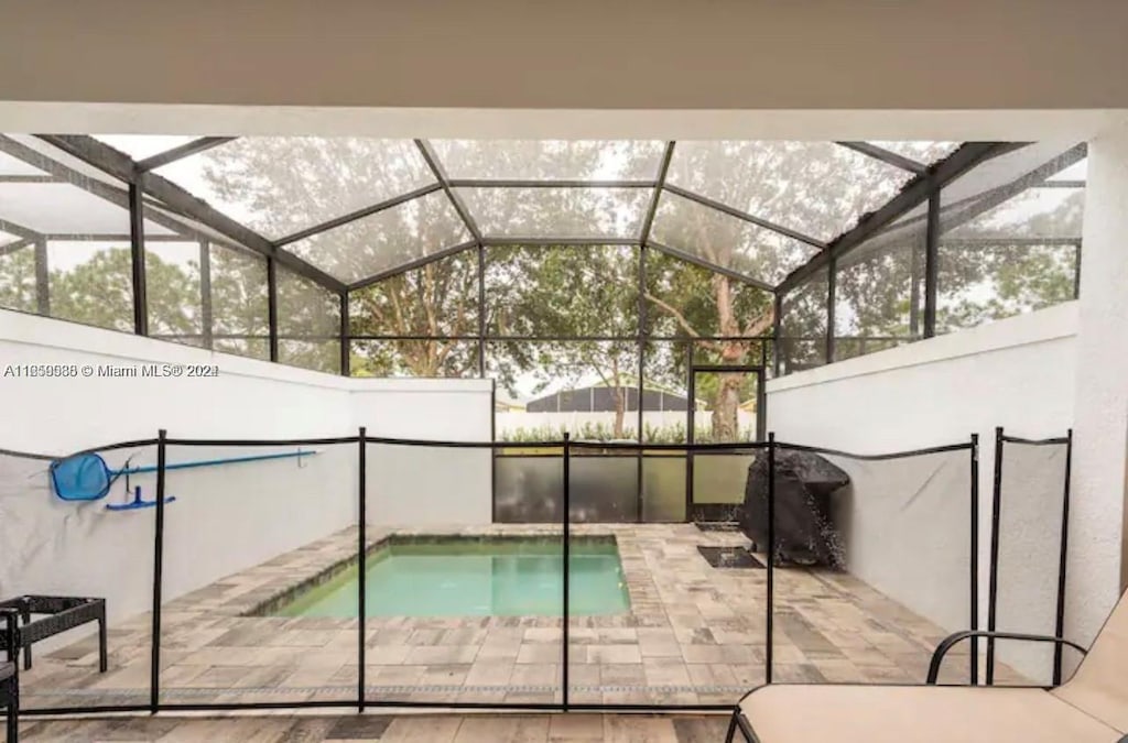 view of pool with a patio and a lanai