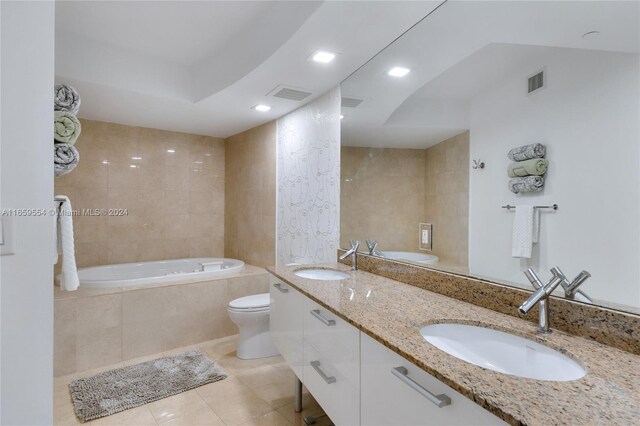 bathroom with tile patterned floors, tiled bath, vanity, and toilet