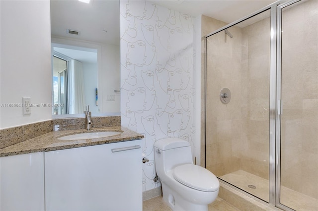 bathroom featuring vanity, toilet, and a shower with shower door