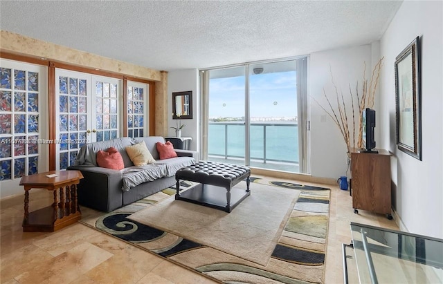 living room with plenty of natural light, french doors, and a textured ceiling