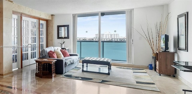 living room with a textured ceiling and a wall of windows