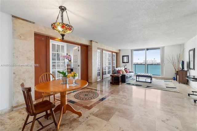 dining space with french doors and a textured ceiling