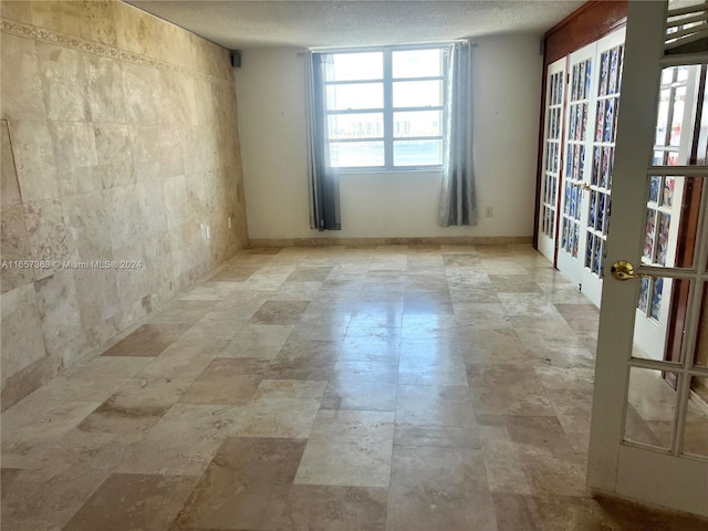 unfurnished room with a textured ceiling