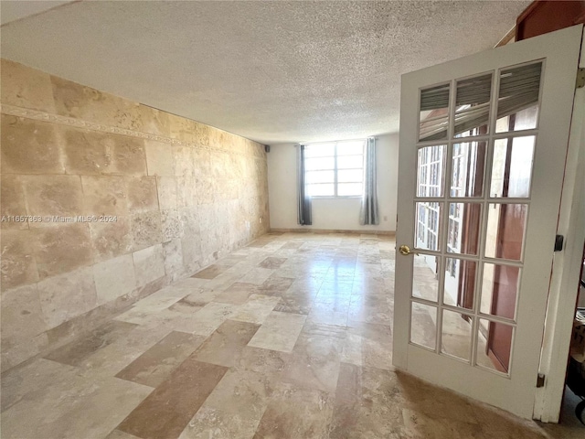 unfurnished room with a textured ceiling