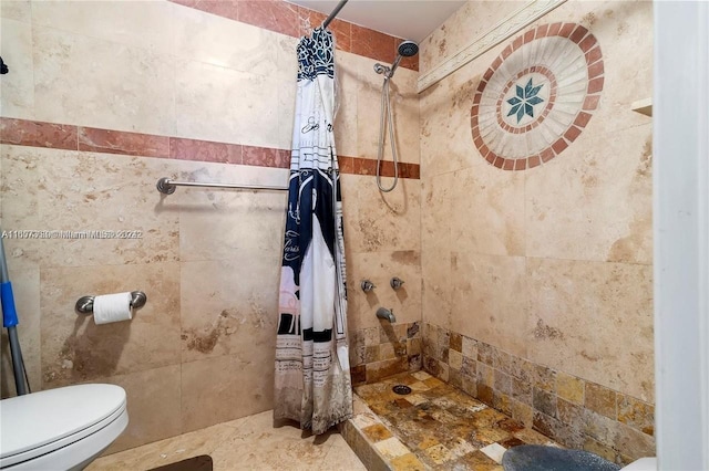 bathroom with tile walls, toilet, and tiled shower
