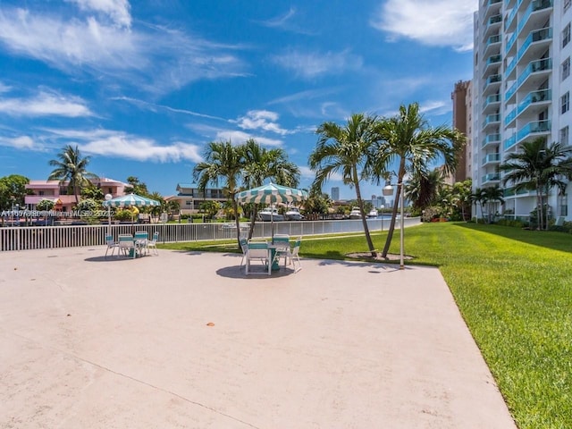 view of property's community featuring a yard, a water view, and fence