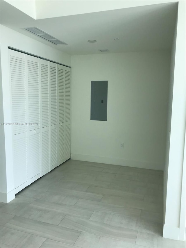 unfurnished bedroom with electric panel and a closet