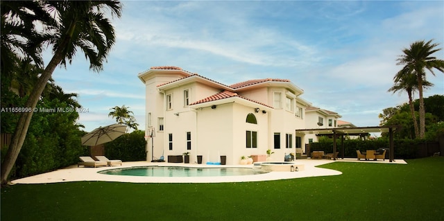 rear view of property featuring a patio, a pergola, and a yard